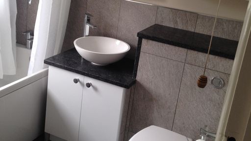 A newly fitting bathroom suite, with tiled boxing around a vanity unit