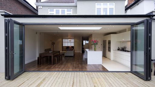 Rear facing kitchen dinner extension with bi-folding doors leading onto garden decking