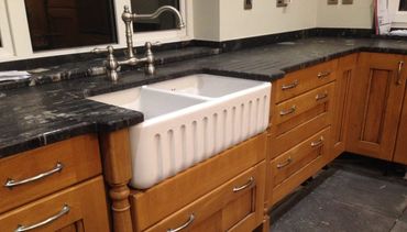 New belfast sink set within a granite worktop, with oak kitchen doors either side