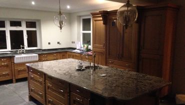 Oak kitchen with granite worktops and sink within a central island