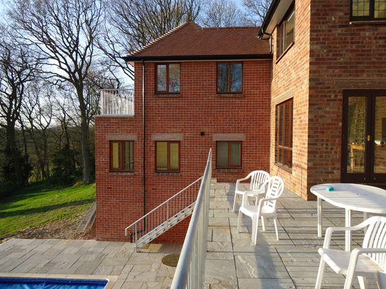 A new upper balcony added with railing overlooking a swimming pool