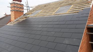 New slate tiles being installed to a client's property, on top of the felt and batten