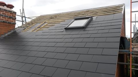 A roof being repaired with a pair of Velux skylight's installed