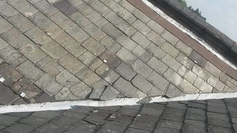 An old roof valley that's displaying signs of years of seasonal weathering and damage